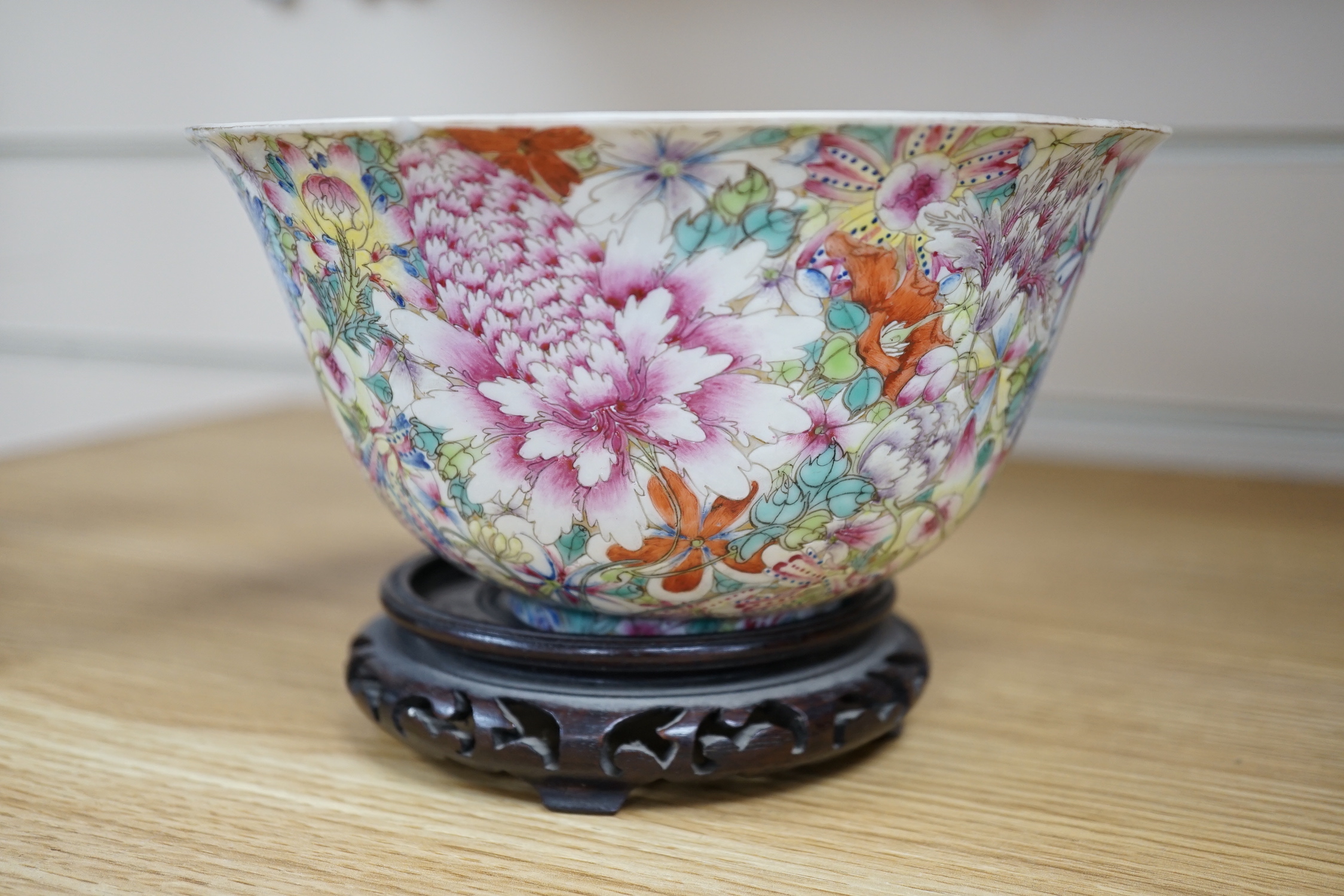 A Chinese 'Thousand Flower' enamelled porcelain bowl, Qianlong mark, early 20th century on hardwood stand, 17cm high